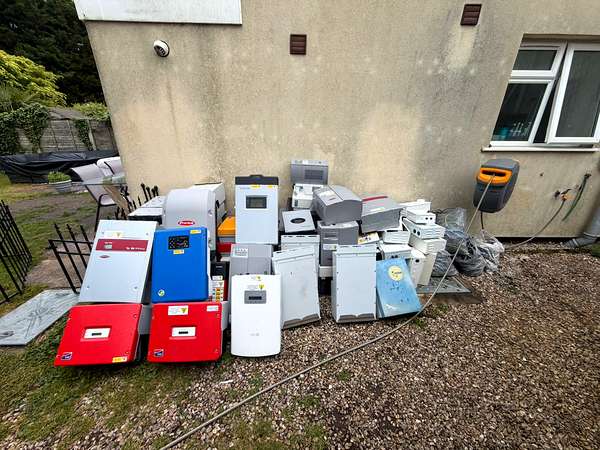 A row of old appliances collected for recycling at the side of a property