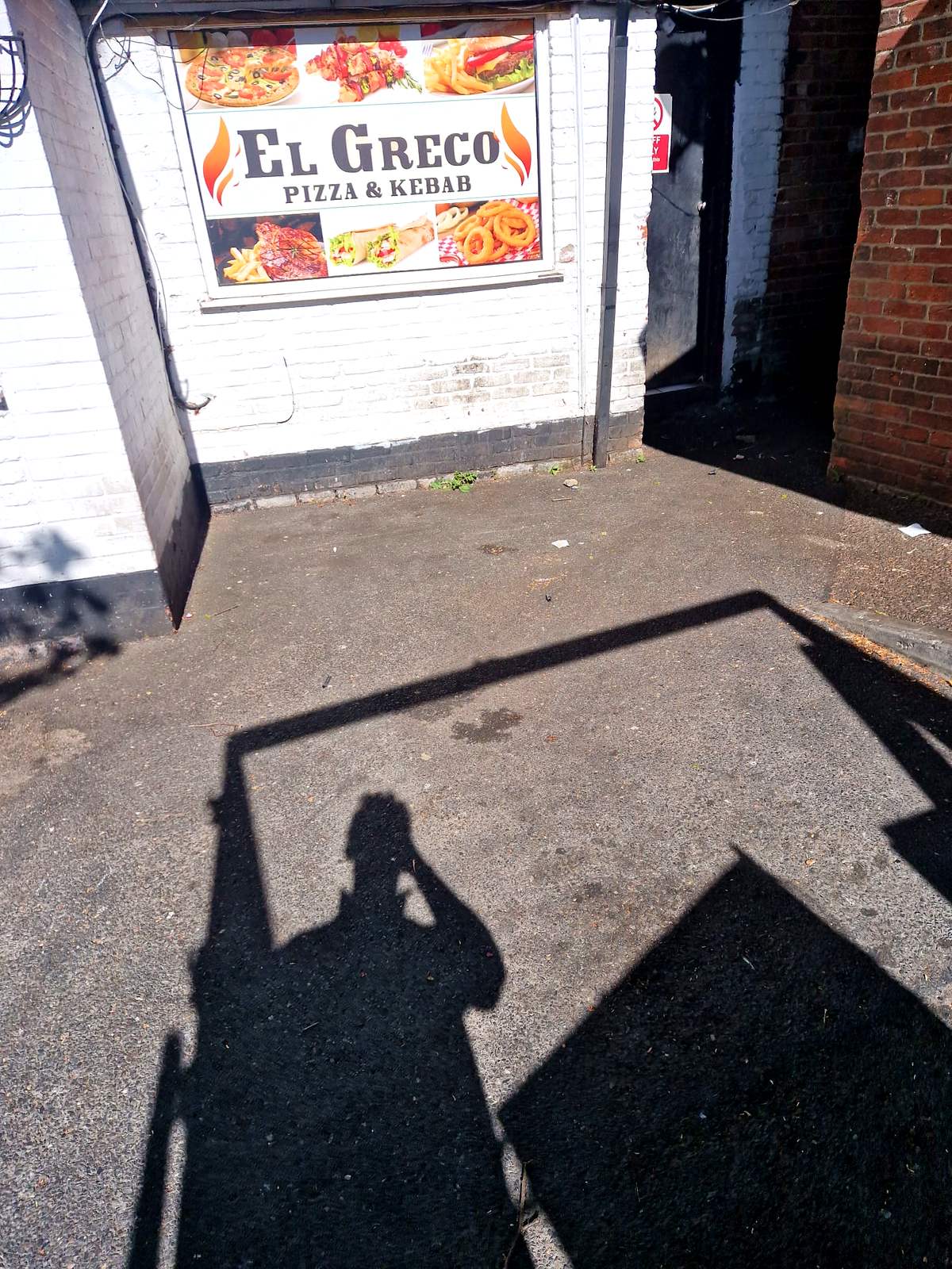 Cleared rear yard behind a high street takeaway after a commercial clearance