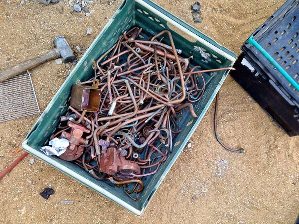 Crate of copper pipe and fittings collected from a plumbing strip out