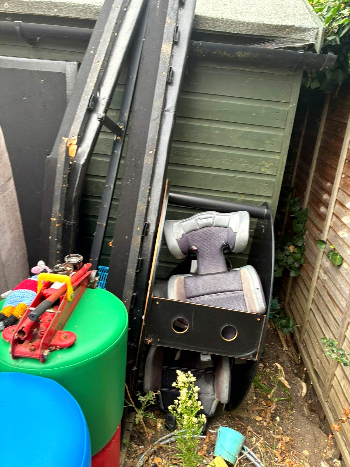 Contents of a garden shed pulled out ready for removal, including an old mobility scooter