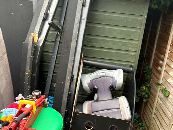 Contents of a garden shed pulled out ready for removal, including an old mobility scooter