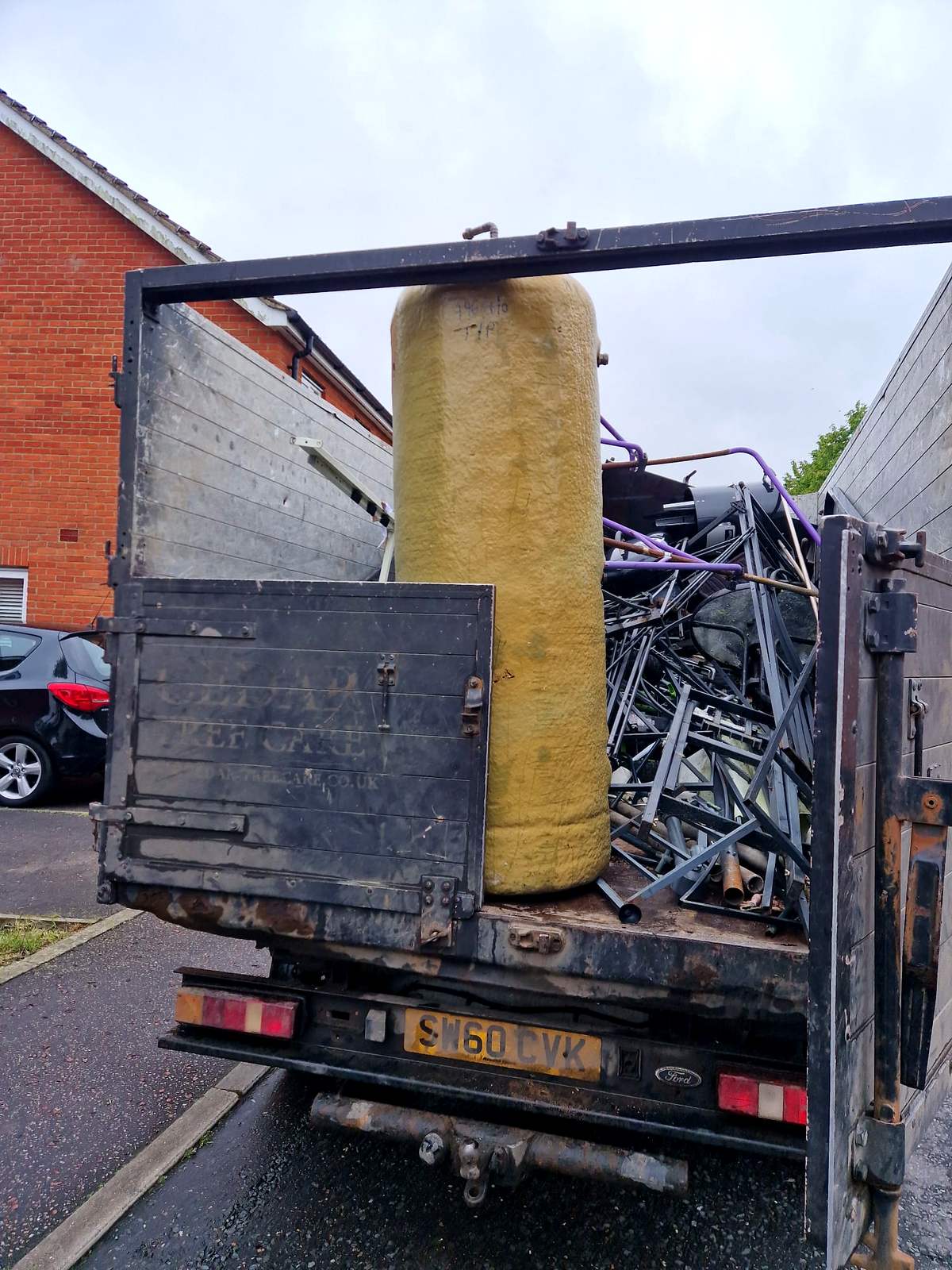 Tipper full of mixed scrap metal and a copper hot water cylinder