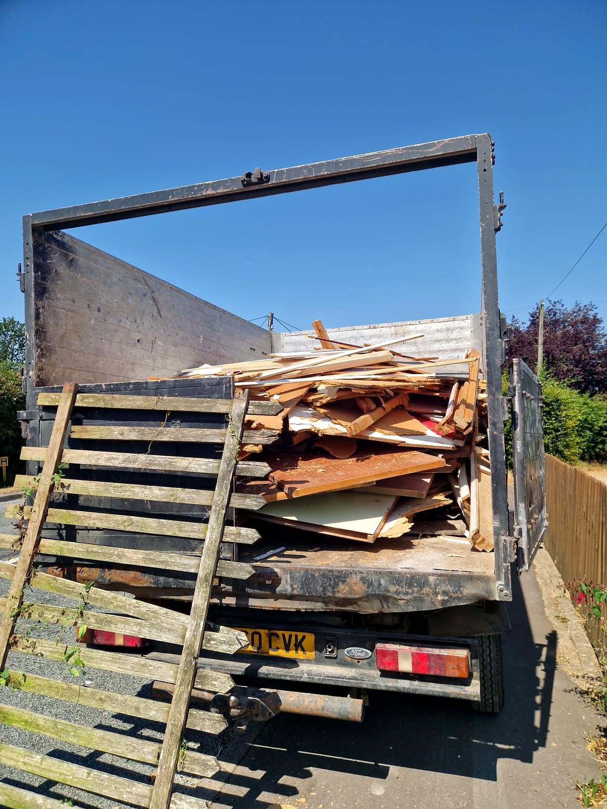 Tipper truck loaded with broken timber and old fencing after a house clearance
